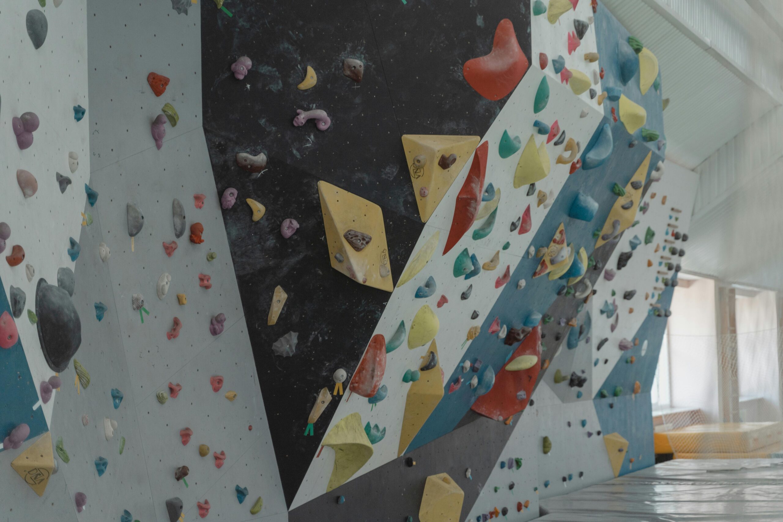 Vibrant indoor climbing wall with colorful holds, perfect for sport enthusiasts seeking adventure.